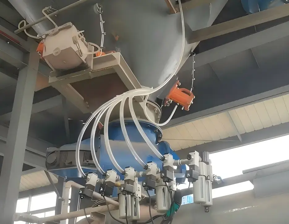 An industrial pneumatic vibrator system installed on a grey steel hopper to effectively resolve material blockages and bridging in a silo.