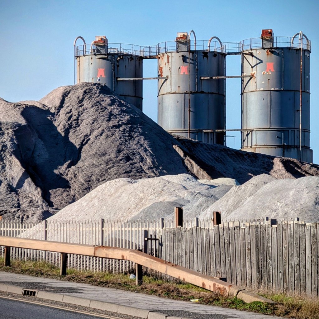 Tall industrial silos surrounded by mounds of materials in Middlesbrough, England